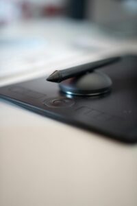 Close-up of a stylus on a black drawing tablet. Perfect for digital art and design work.